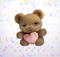 a brown teddy bear holding a pink heart