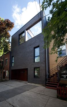 the house is made out of black bricks and has two stories on each level that are connected to one another