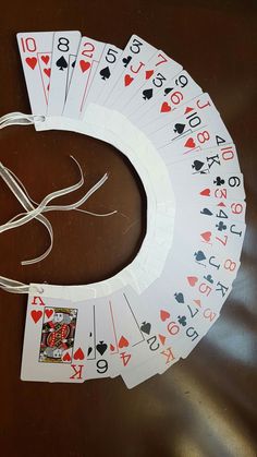 four playing cards are laid out on a table with string attached to them, and one is empty