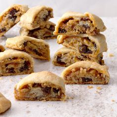 several pieces of fruit filled pastry sitting on top of a white paper covered countertop