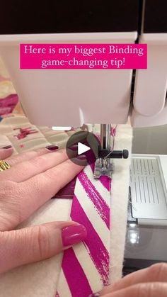 a woman is using a sewing machine to sew on her pink and white striped shirt