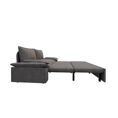 a gray sectional sofa with pillows on the back and foot rest in front of it