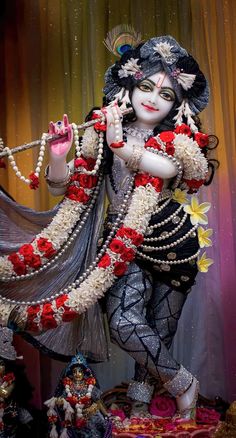 a statue of the hindu god srishri with flowers around his neck and hands