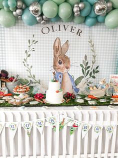 a table topped with cake and desserts next to balloons in the shape of bunnies