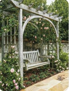 a white bench sitting under a wooden arbor