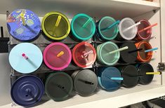 many different colored cups and spoons are on the shelf