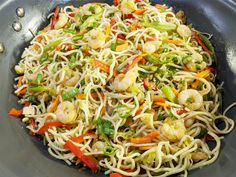 a bowl filled with noodles and vegetables on top of a table