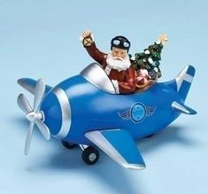 a santa clause riding on top of a blue plane