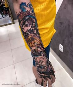 a man's arm with tattoos on it and an anime character in the background