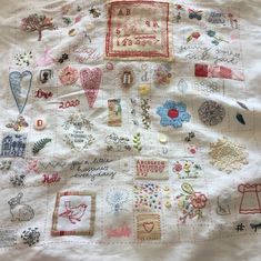 a white quilt covered in lots of different types of stitchs and appliques