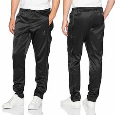 Adidas Originals Men's Adicolor Button Down Pant [Black/Legend Ink] Features: - Lightweight smooth, satin-like fabric offers amazing comfort and quality. - Adidas Retro Originals - Stretch properties enable better mobility. - Snap-button down sides grant easy on-and-off. - Drawcord elastic waistband for a perfect fit. - Tapered leg for a contemporary atheleisure look and feel. - Trefoil trademark design logo adorns the left side. - Fit: True to Size. - Color/Style: Black (BK0026) and Legend Ink Trademark Design, Black Legends, Adidas Adicolor, Adidas Retro, Button Pants, Adidas Mens, Adidas Originals Mens, Active Wear Tops, Pants Black