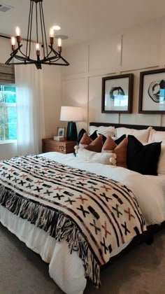 a bedroom with a bed, chandelier and pictures on the wall