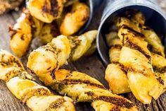 grilled bananas are sitting on a wooden table next to some tins filled with them