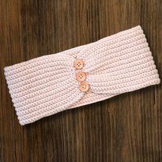 a white knitted headband with buttons on it