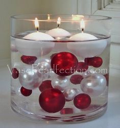 a glass bowl filled with white and red ornaments