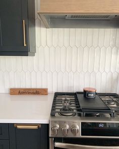 a stove top oven sitting inside of a kitchen next to a wooden sign with the word love on it