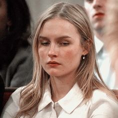 a woman with long hair sitting in front of other people