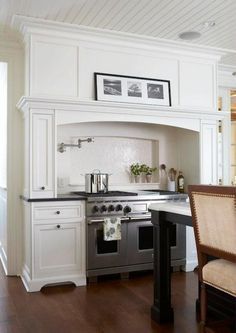 a kitchen with an oven, stove and dining room table in the corner by the window