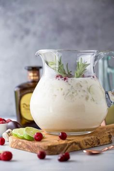 a pitcher filled with liquid sitting on top of a cutting board next to other ingredients