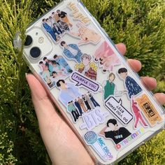 someone holding up a phone case with stickers on it