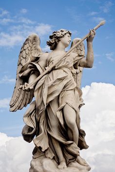 an angel statue holding a trumpet in its right hand and looking up at the sky