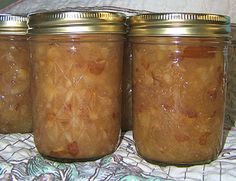 three jars filled with food sitting on top of a white tablecloth covered bed next to each other