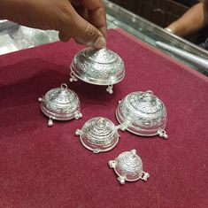 a person is touching some silver items on a table