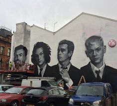 a large mural on the side of a building with men in suits and ties painted on it