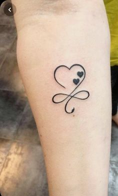 a small heart tattoo on the arm