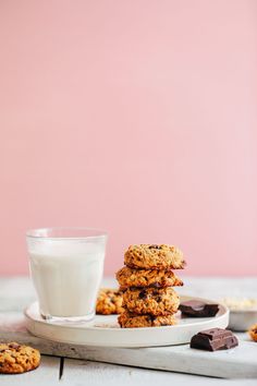 cookies and milk on a white plate with pink wall in the backgroung