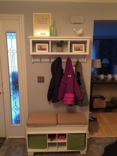 a coat rack with two coats hanging from it's sides and three shoes on the top shelf