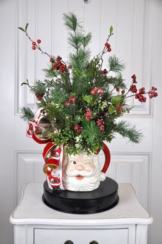 a christmas plant in a santa claus mug with holly and candy canes on top