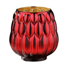 a red glass vase with gold accents on the top and bottom, sitting in front of a white background