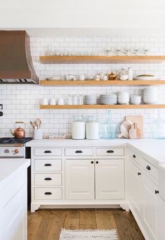 the kitchen is clean and ready for us to use it's shelves are filled with dishes