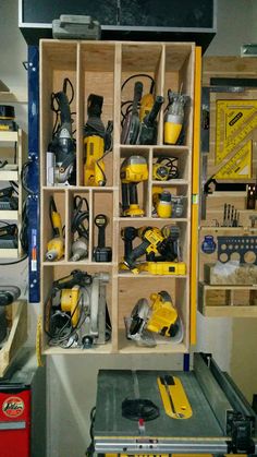 there are many different tools in the storage area on this shelf, including drillers and screwdrivers