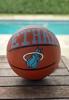 a basketball sitting on top of a wooden table next to a pool