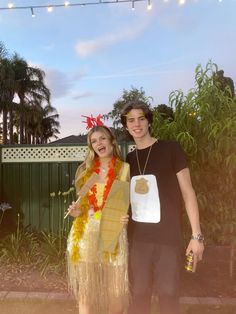 a man and woman dressed up in costumes posing for a photo with palm trees behind them