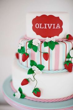 a three tiered cake decorated with strawberries and flowers