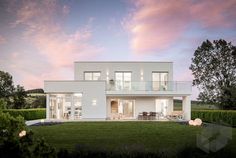 a large white house sitting on top of a lush green field