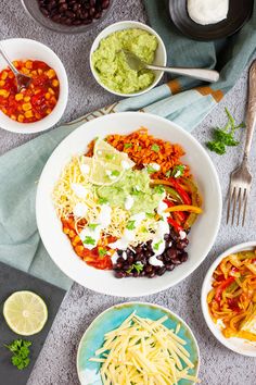 a bowl filled with rice and beans next to other bowls full of food on the table