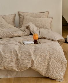 a bed with two pillows and an orange on the end table in front of it