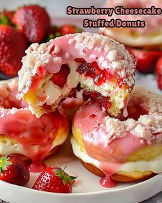 strawberry cheesecake stuffed doughnuts on a plate with strawberries