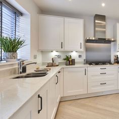 a kitchen with white cabinets and stainless steel appliances