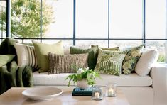 a living room filled with lots of furniture and pillows on top of a wooden table