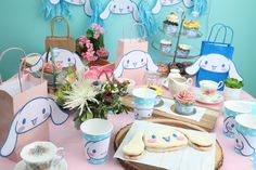 a table topped with lots of cupcakes next to bags filled with flowers and bunnies