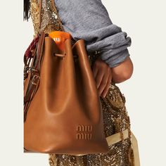 Miu Miu bucket bag in fine calf leather  Adjustable buckle shoulder strap  Drawstring closure  Approx. 11.4"H x 6.7"W x 5.1"D Made in Italy Brown Miu Miu Bag With Gold-tone Hardware, Miu Miu Brown Bag With Gold-tone Hardware, Brown Miu Miu Shoulder Bag With Gold-tone Hardware, Miu Miu Brown Bag With Detachable Strap, Brown Miu Miu Shoulder Bag With Detachable Strap, Miu Miu Brown Shoulder Bag With Detachable Strap, Elegant Brown Miu Miu Bag, Elegant Brown Miu Miu Shoulder Bag, Designer Brown Miu Miu Bag