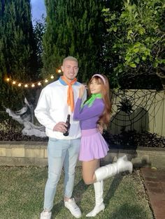 a man and woman dressed up in costume posing for a photo together outside at night