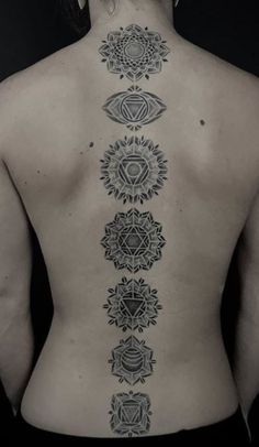 the back of a woman's body with tattoos on her upper and lower back