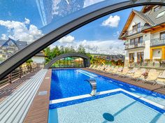 an outdoor swimming pool surrounded by lounge chairs