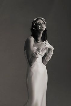 a woman in a white dress is posing for the camera